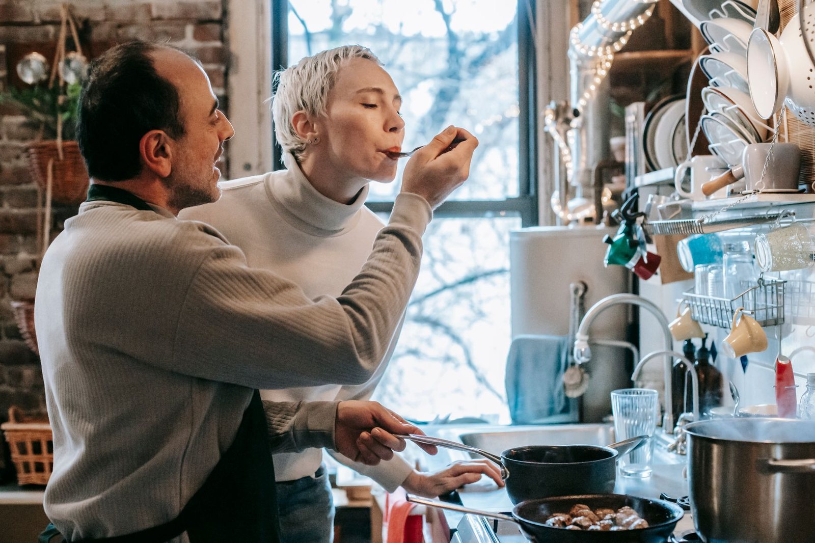 Pareja cocinando junta en casa, reflejo de la compatibilidad de signos lunares