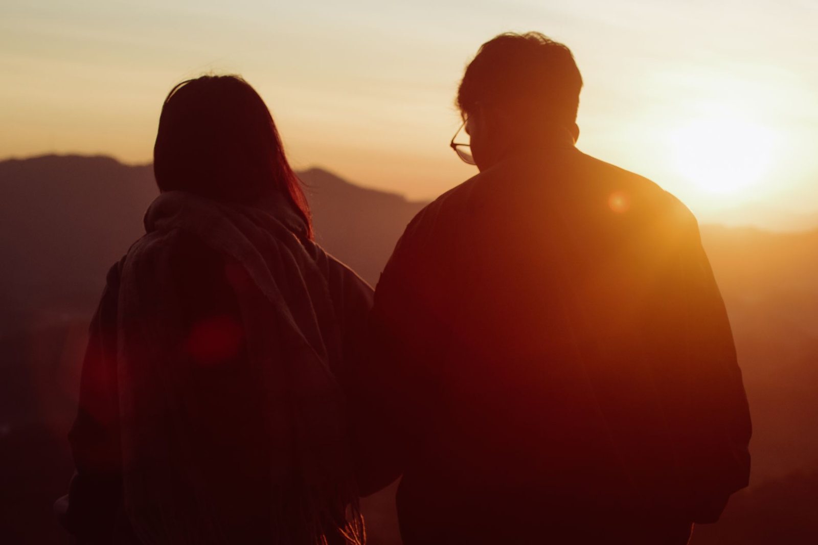Pareja haciendo senderismo al amanecer, energía compartida de Marte y ascendente