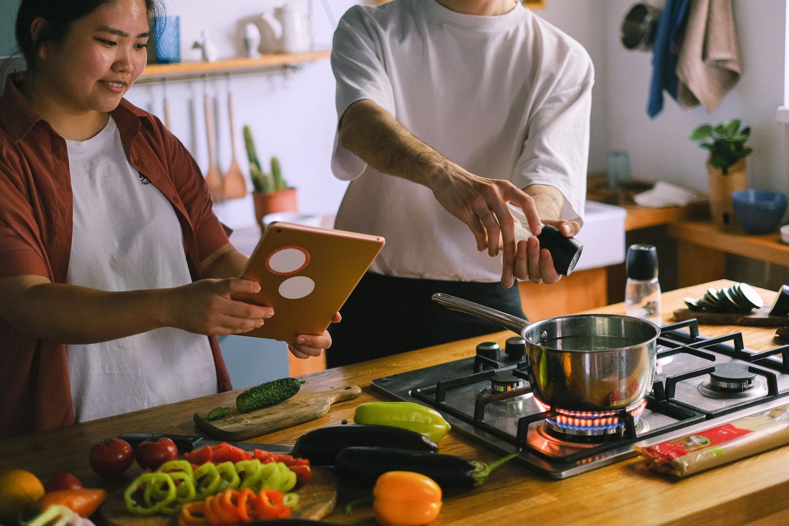 Pareja cocinando junta en casa, complicidad cotidiana propia de este aspecto astrológico