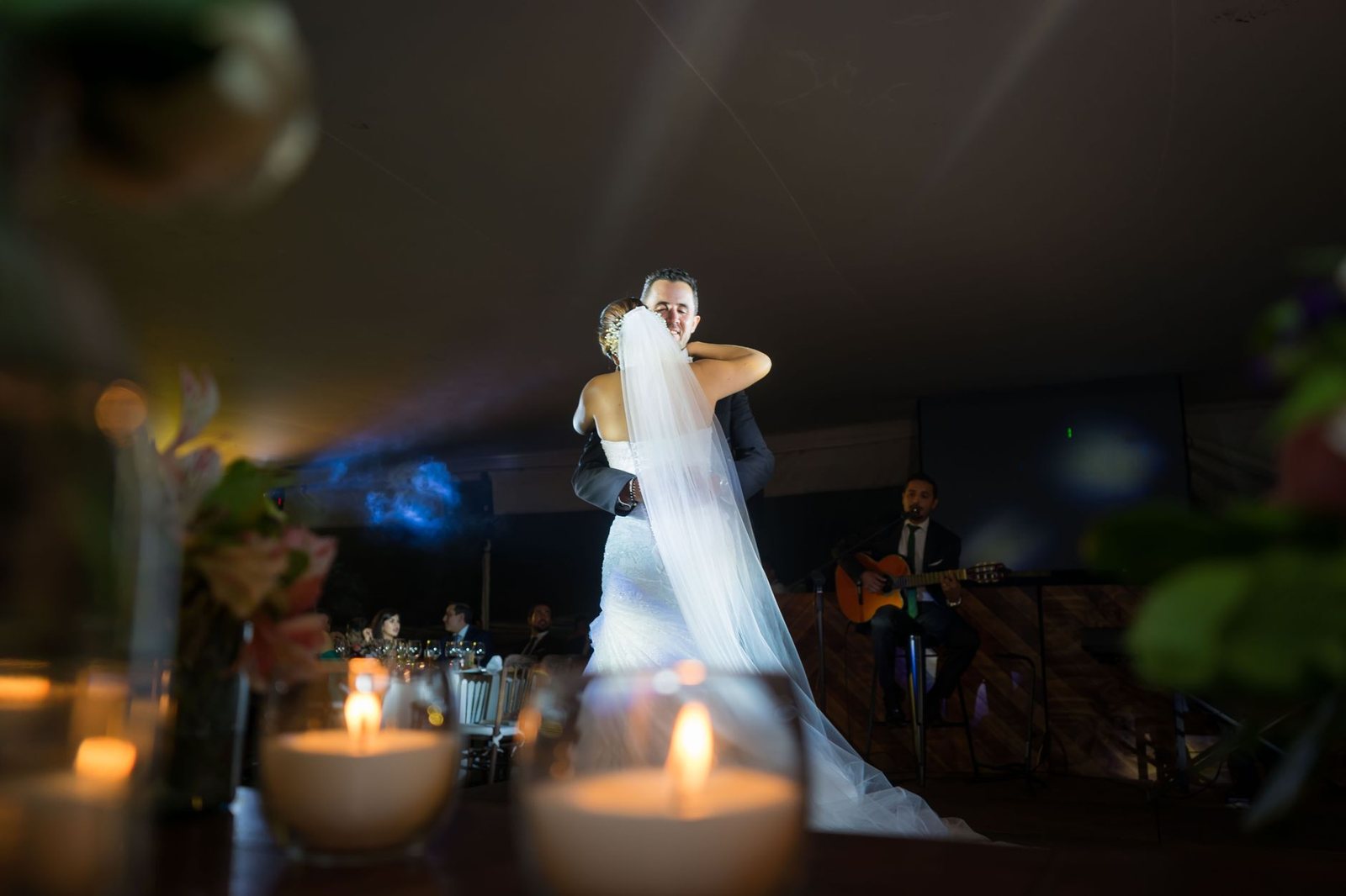 Pareja bailando muy juntos a la luz de las velas con mirada intensa