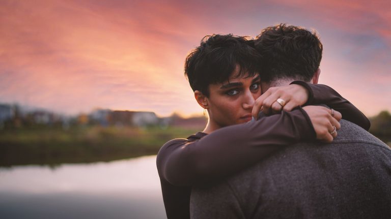 Pareja abrazada al atardecer, imagen de la química de sinastría Venus conjunción Marte