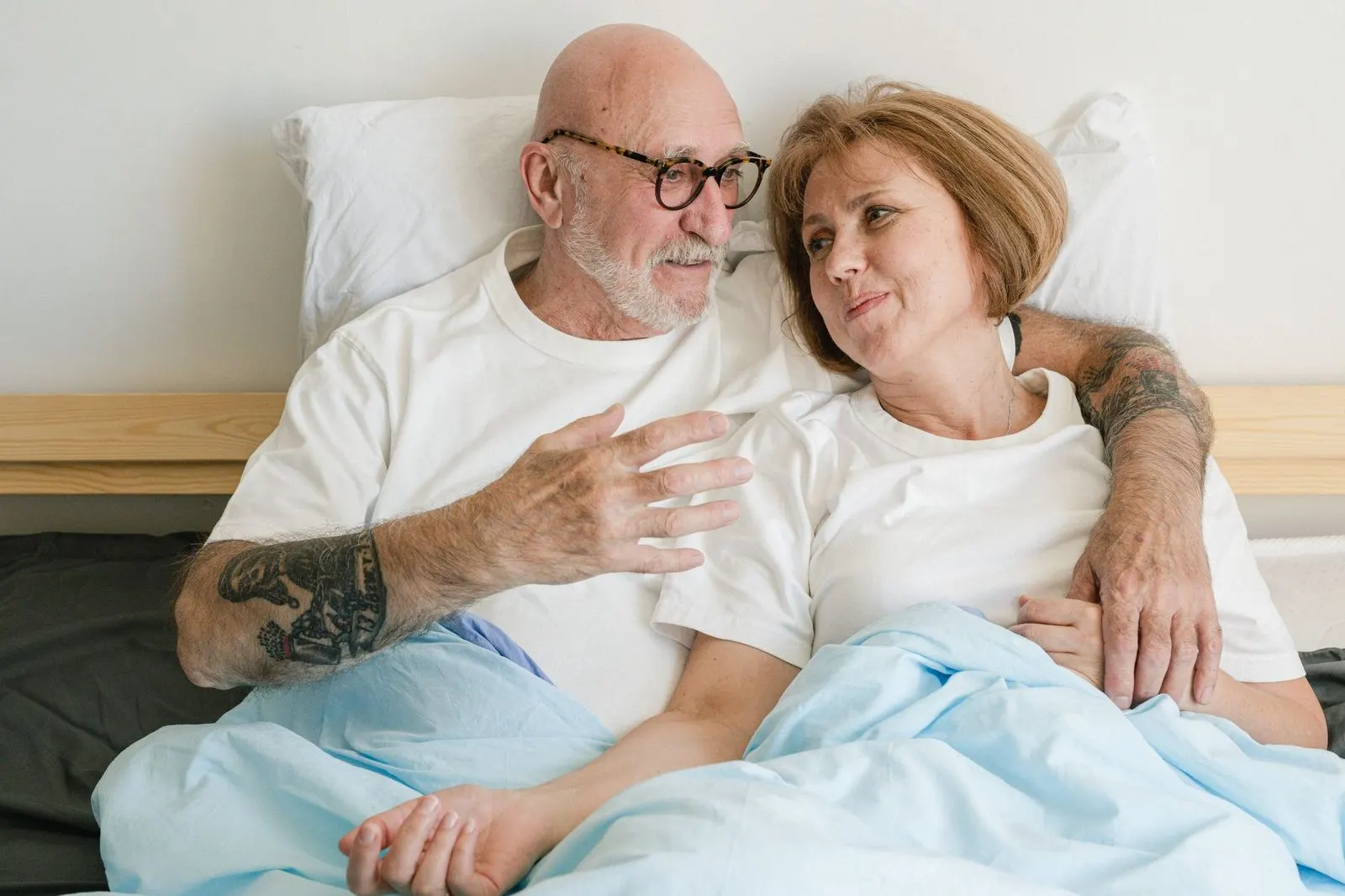 Pareja conversando tranquila en la cama por la mañana, complicidad entre Acuario y Virgo