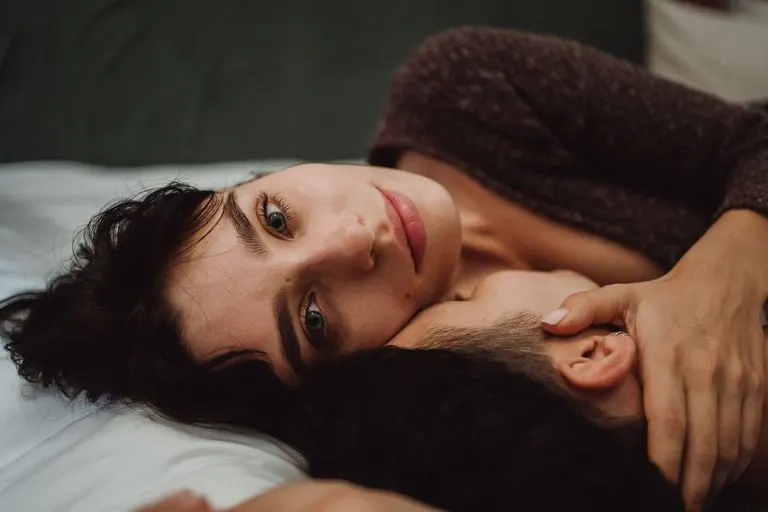 Acuario y Virgo en la cama: deseo, ritmo y química Pareja abrazada en un dormitorio con luz suave, reflejo de Acuario y Virgo en la cama