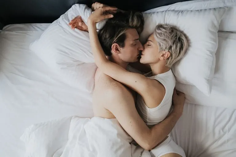Aries en la cama: así es el signo de fuego en la intimidad Pareja abrazada con pasión en un dormitorio, imagen de Aries en la cama
