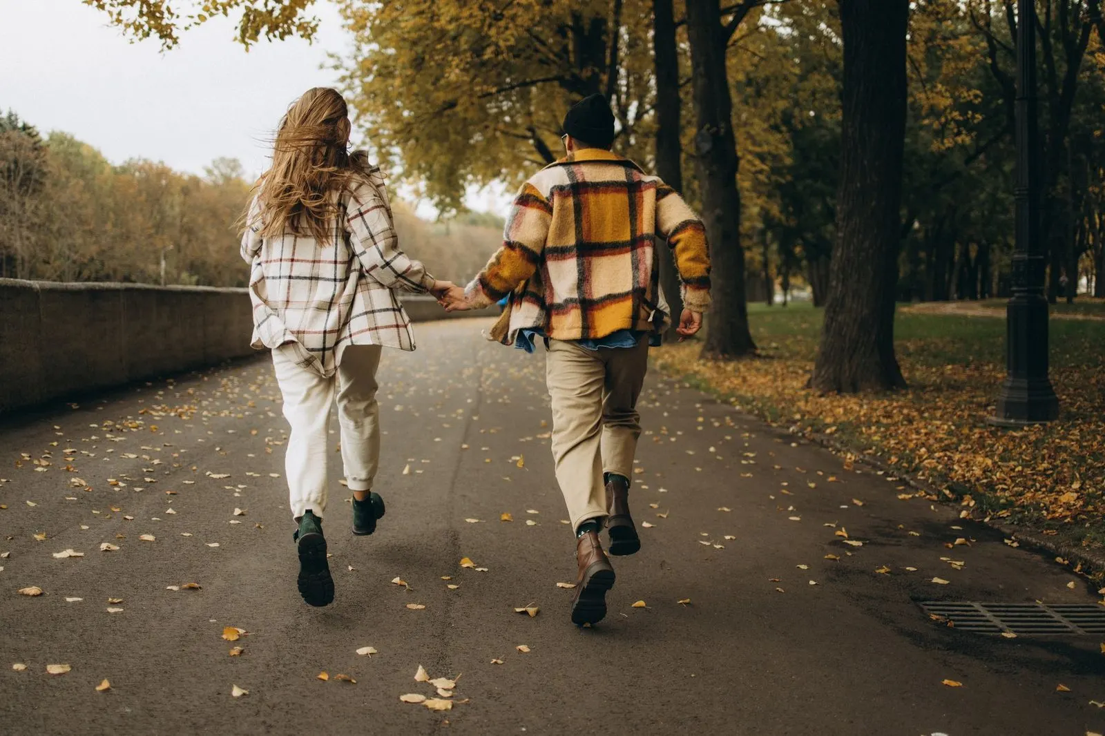 Pareja corriendo de la mano con la energía impulsiva de un Aries enamorado