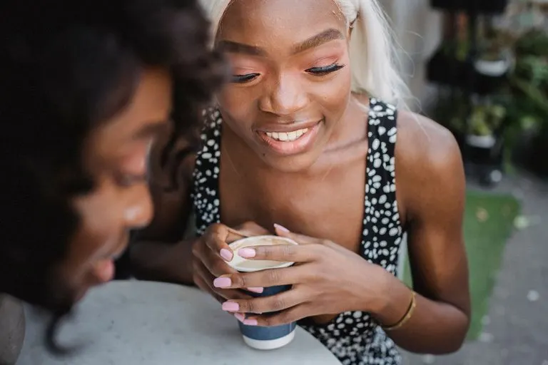 Mujer con ascendente Géminis riendo mientras conversa animadamente en una cafetería