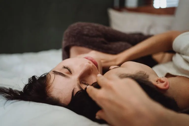 Cáncer y Capricornio en la cama: química y deseo Pareja abrazada en la cama que refleja la química de Cáncer y Capricornio
