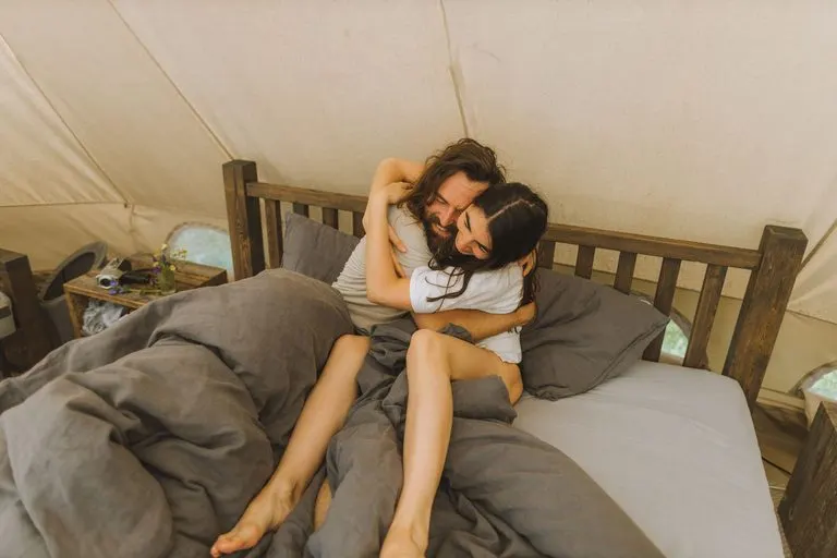 Cáncer y Géminis en la cama: deseo, juego y ternura Pareja abrazada en la cama, imagen de Cáncer y Géminis en la cama