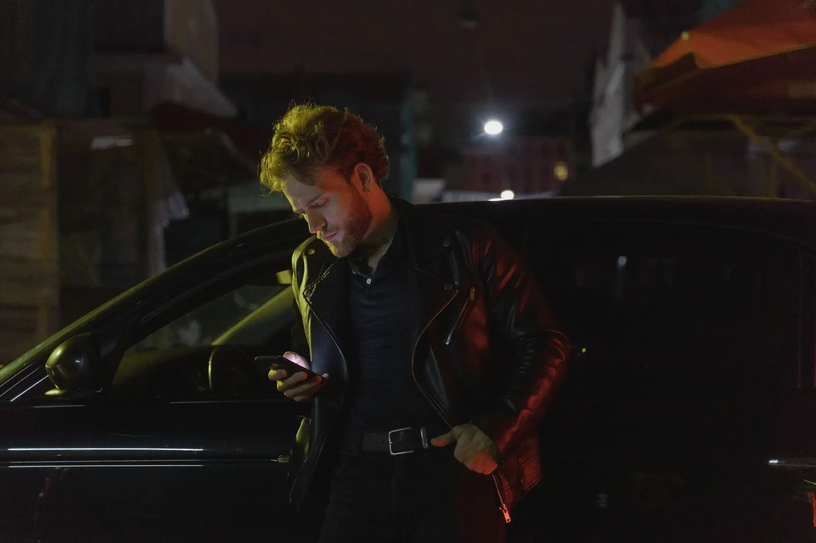 Hombre Aries mirando el móvil de noche porque echa de menos a alguien