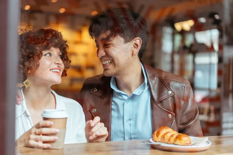 Pareja en su primera cita mirándose, reflejo de la compatibilidad ascendente y la atracción