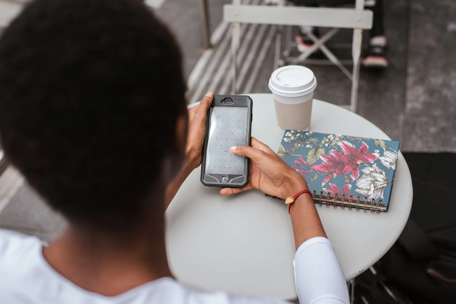 Mujer escribiendo un mensaje de WhatsApp en una cafetería con luz cálida
