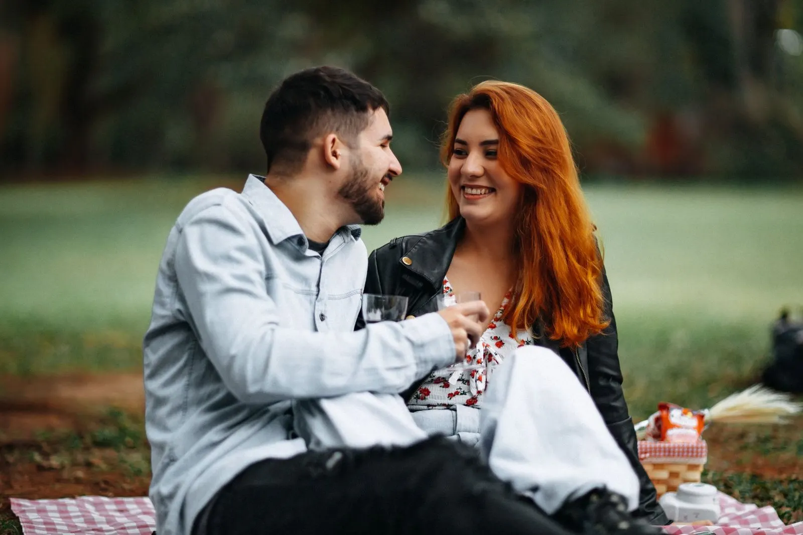 Pareja riendo en una cita al aire libre tras conocerse por mensajes