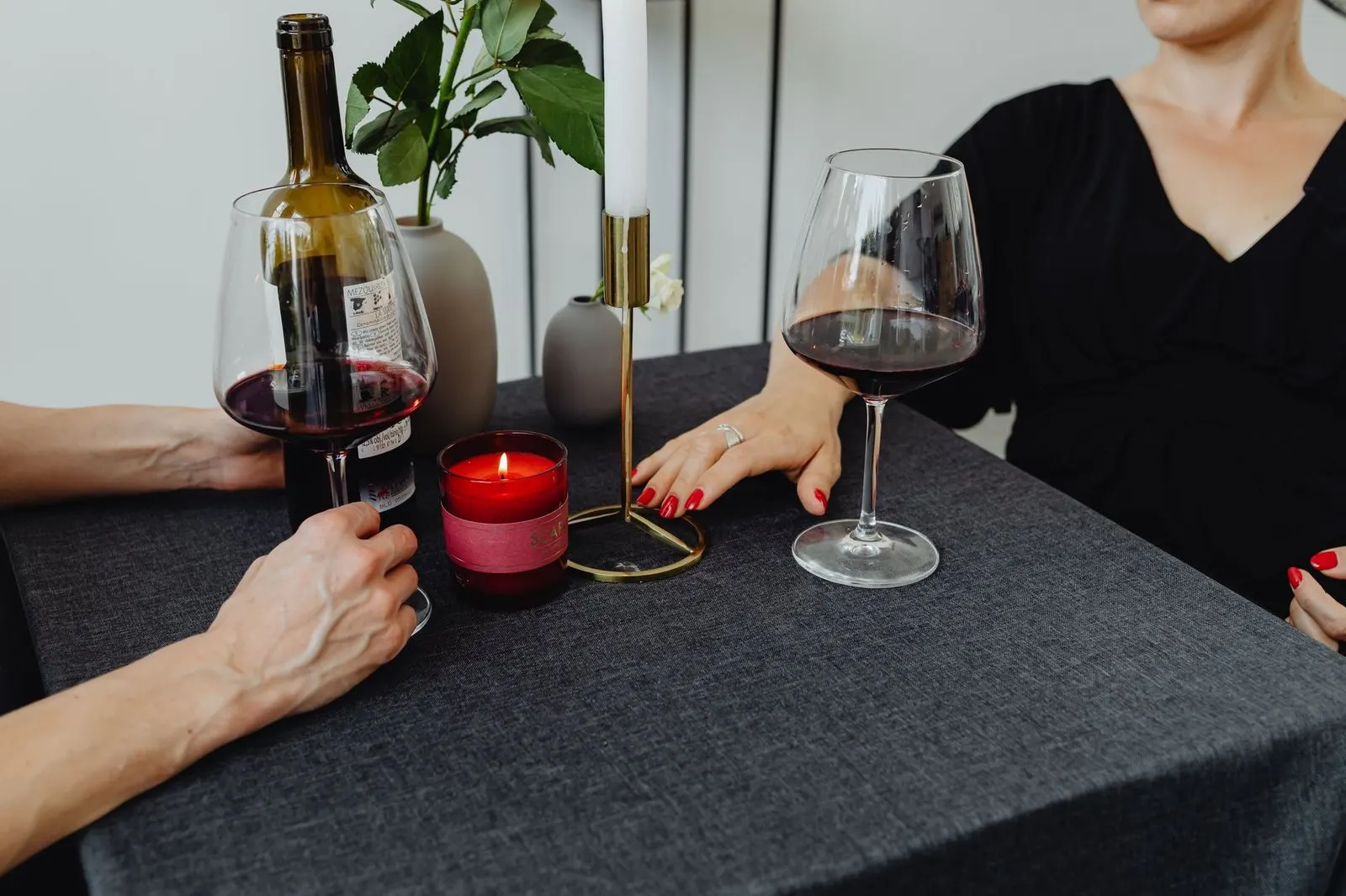 Pareja compartiendo una cena tranquila con vino tras conocerse por mensajes
