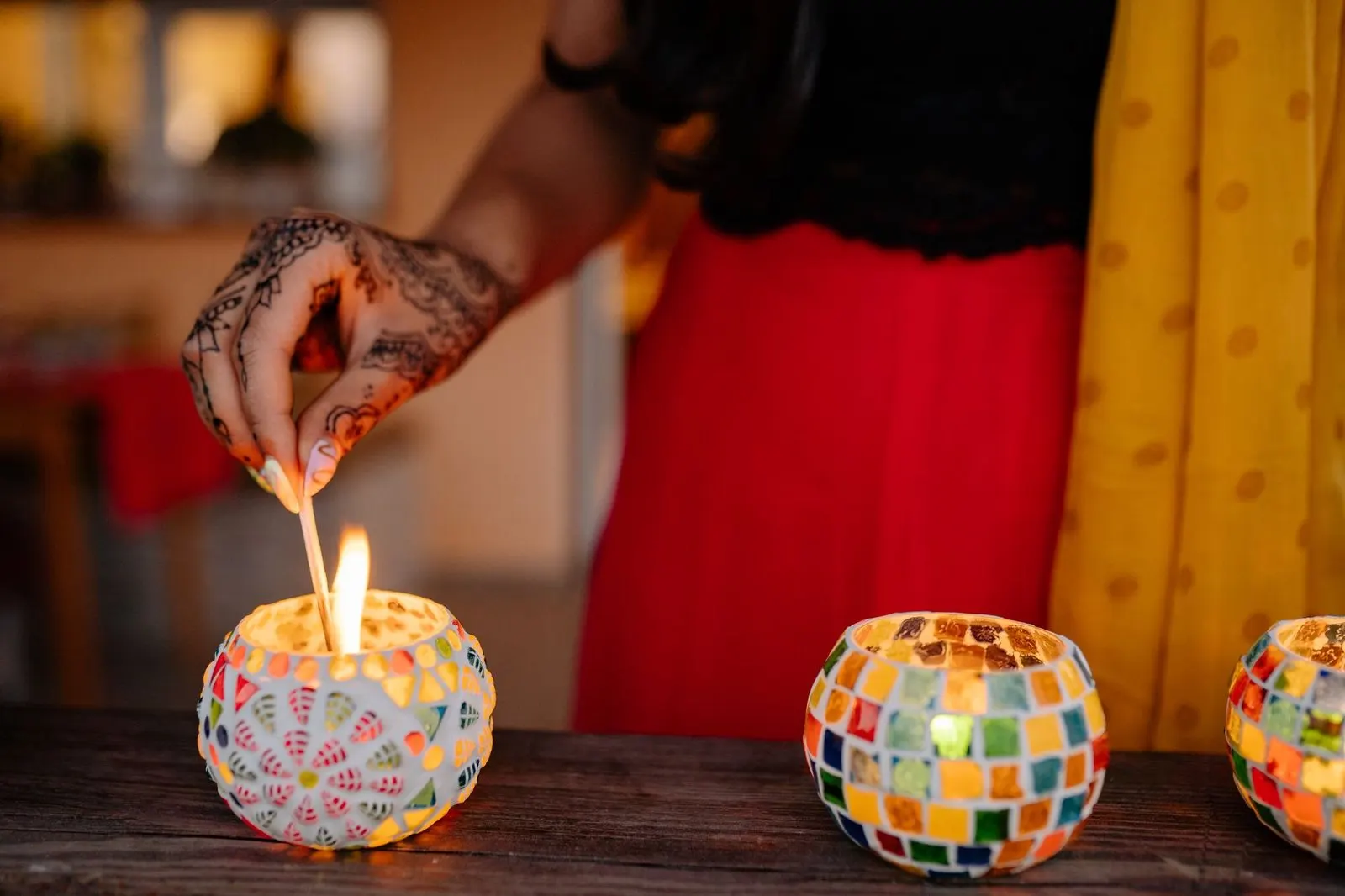 Mujer encendiendo una vela, símbolo del fuego interior del descendente en Aries