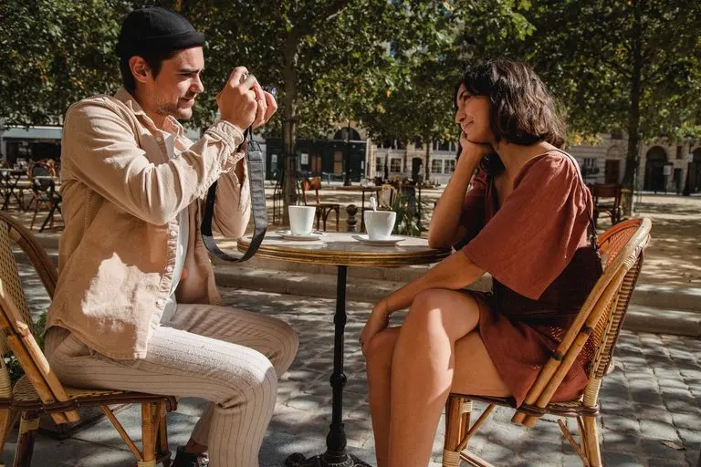 Pareja conversando y riendo en una cafetería, energía del descendente en Géminis