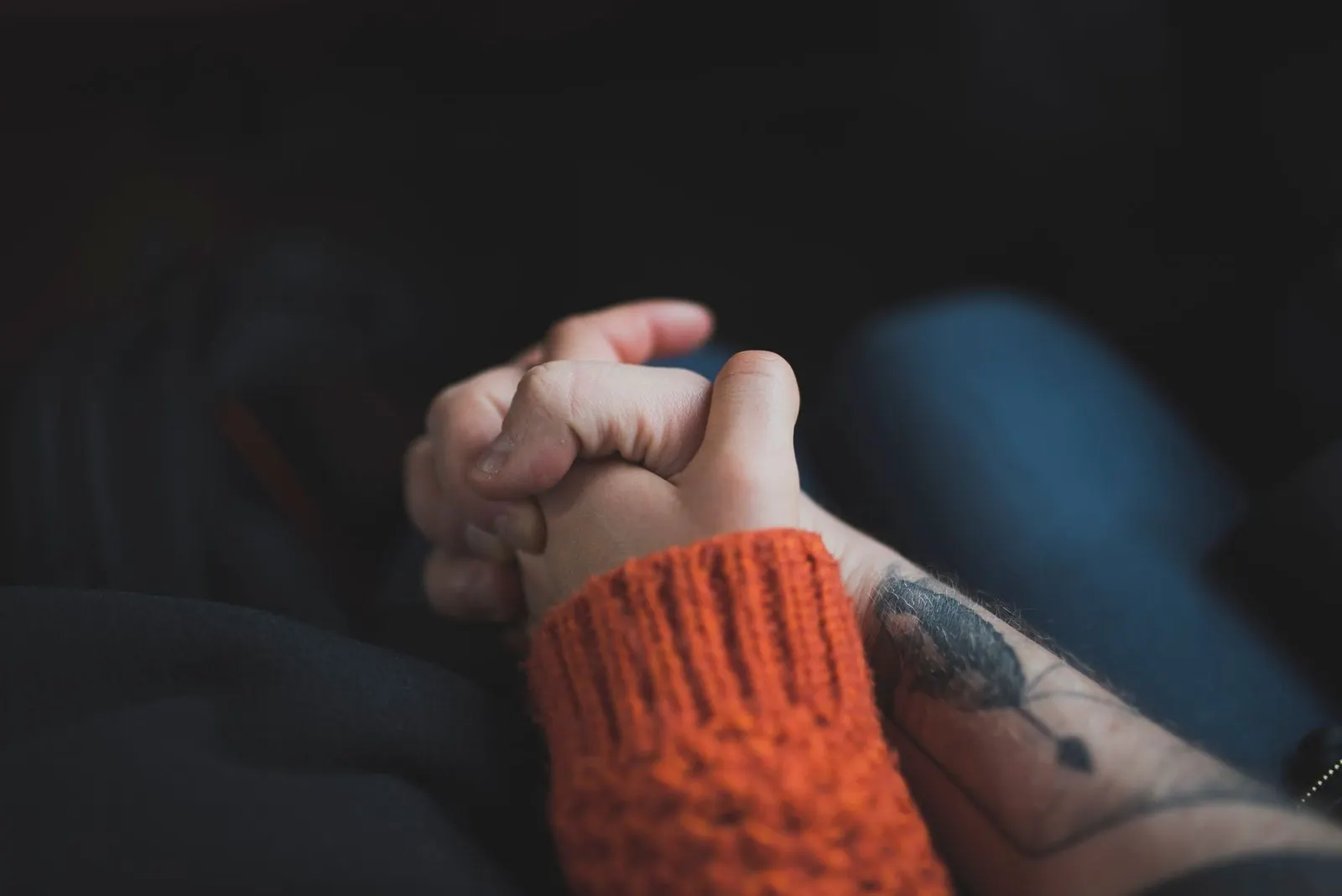 Pareja cogida de la mano bajo luz cálida, reflejo del descendente Leo en pareja