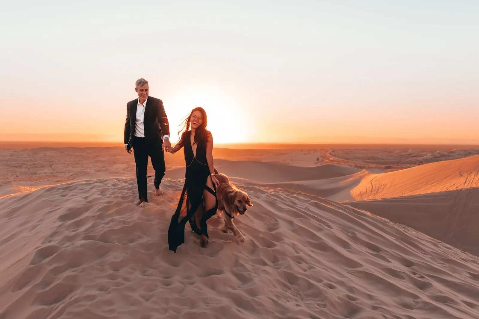 Pareja riendo al atardecer dorado, símbolo del descendente en Leo en el amor