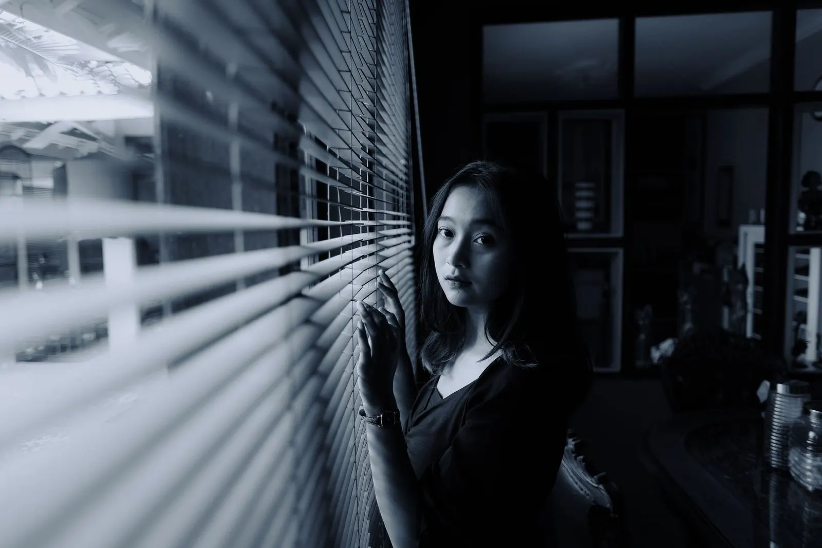 Mujer de mirada intensa junto a la ventana con energía magnética de Escorpio