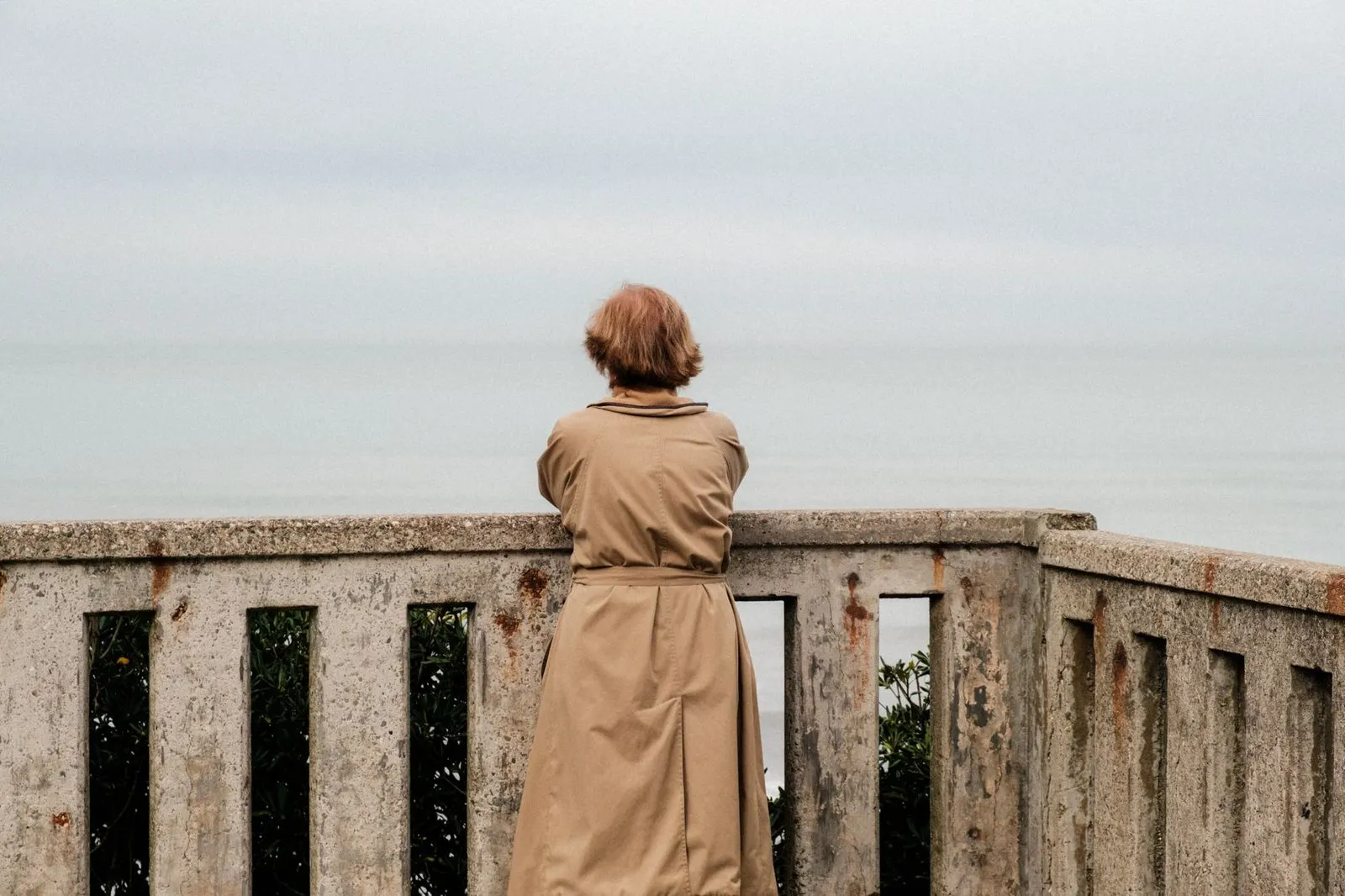 Mujer contemplando el mar en calma, energía de Piscis y Aries en el amor