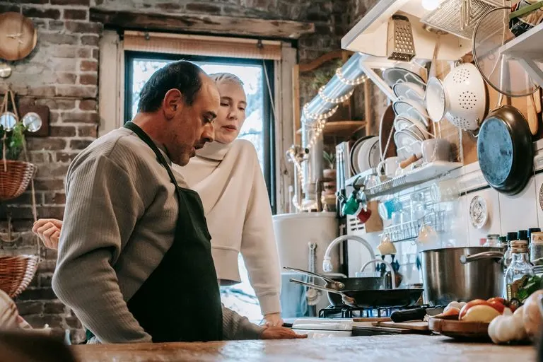 Pareja cocinando junta en casa, cómo enamorar a un Cáncer si soy Sagitario