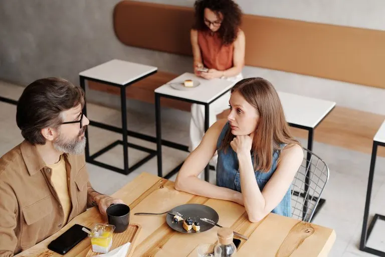 Pareja conversando en una cafetería, cómo enamorar a un Capricornio si soy Acuario
