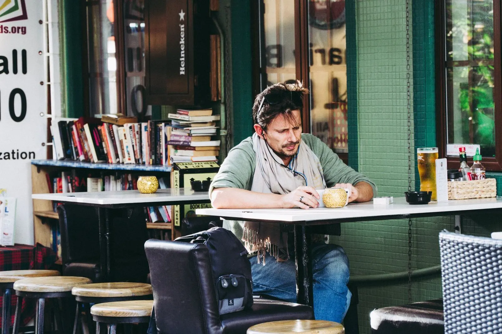 Hombre serio leyendo en una cafetería, reflejo del carácter reservado de Capricornio