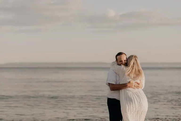 Pareja abrazada junto al mar, reflejo de cómo enamorar a un Escorpio siendo Piscis