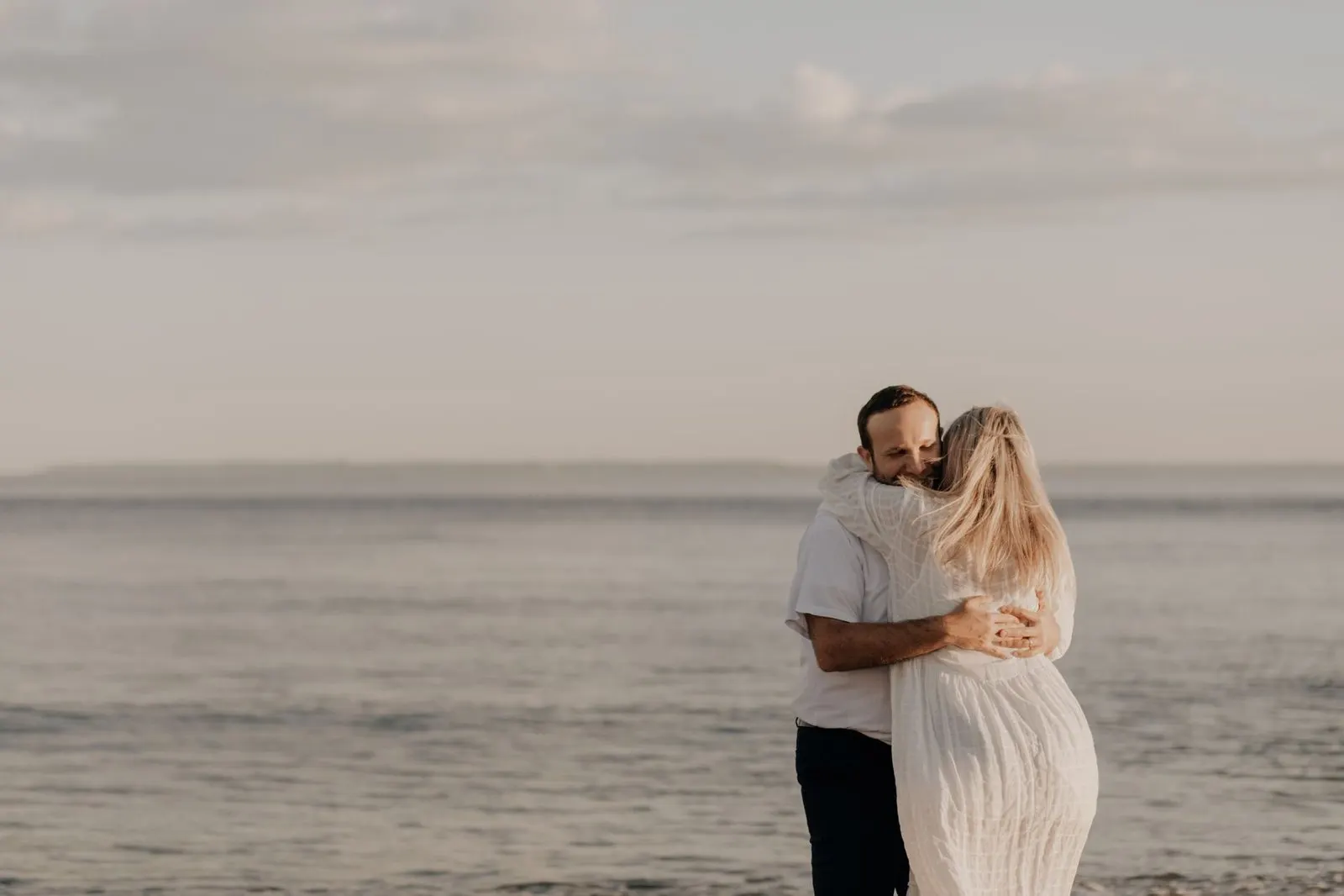Pareja abrazada junto al mar, reflejo de cómo enamorar a un Escorpio siendo Piscis
