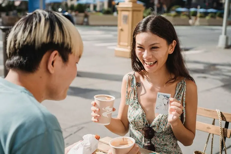 Pareja riendo en una cafetería: cómo enamorar a un Géminis siendo Escorpio