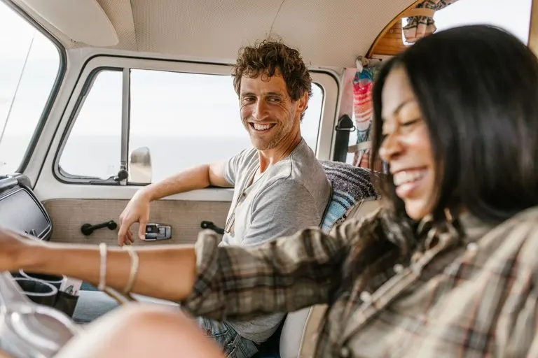 Pareja riendo durante un viaje en coche, cómo enamorar a un Géminis si soy Sagitario