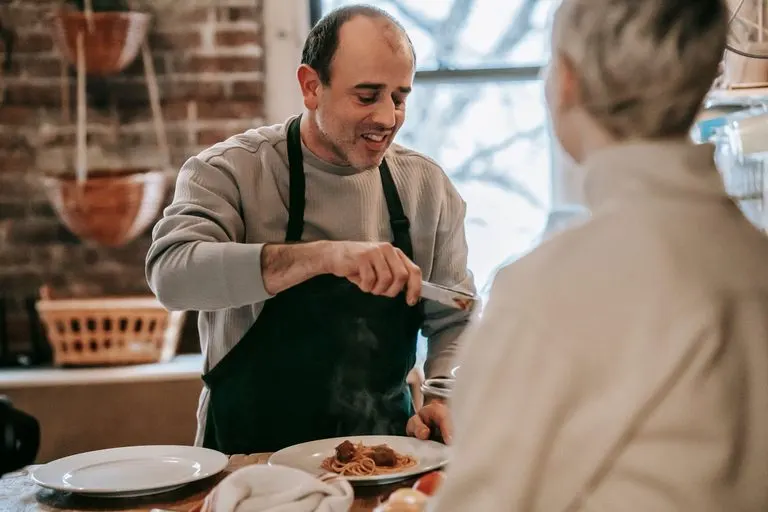 Cómo enamorar a un Leo si soy Cáncer: Luna y Sol Pareja cocinando juntos en casa, idea para enamorar a un Leo si eres Cáncer