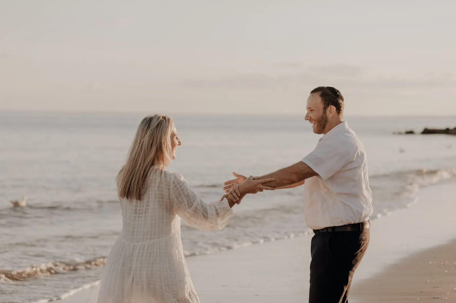 Pareja riendo al atardecer bajo una luz dorada, Libra y Leo en el amor