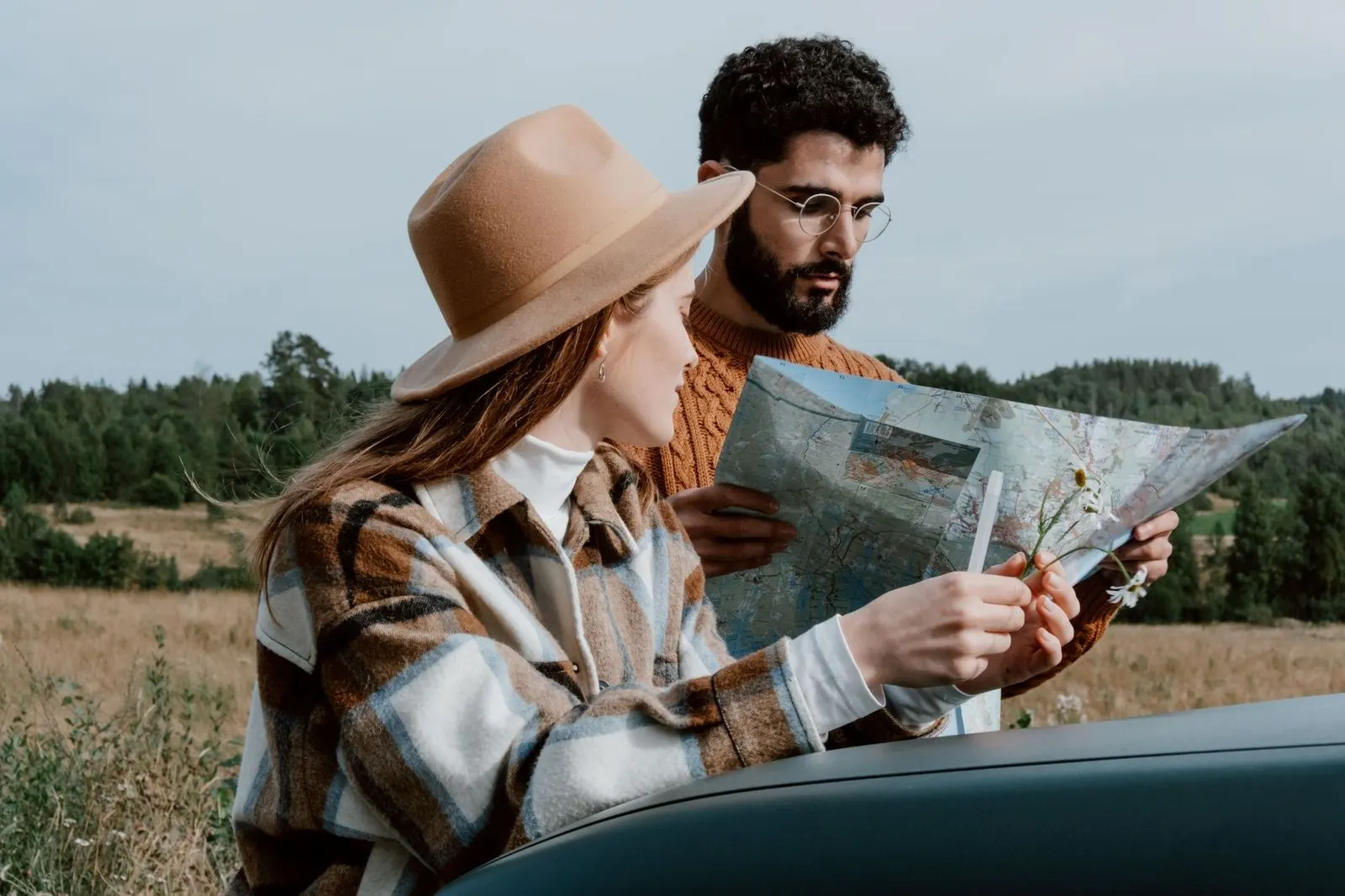Pareja planeando un viaje con un mapa, complicidad entre Sagitario y Leo