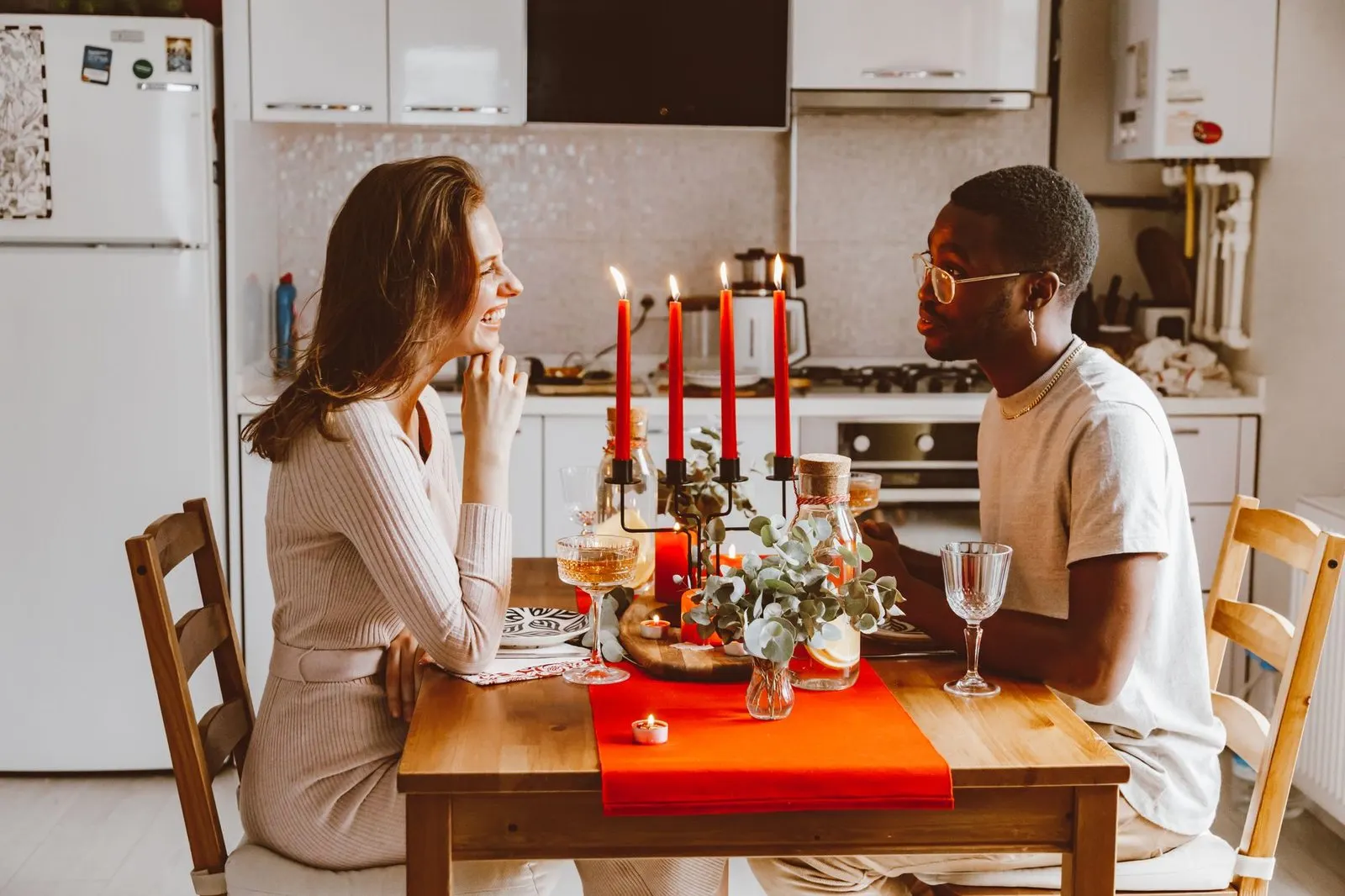 Mujer Escorpio y hombre Aries conversando durante una cena con velas