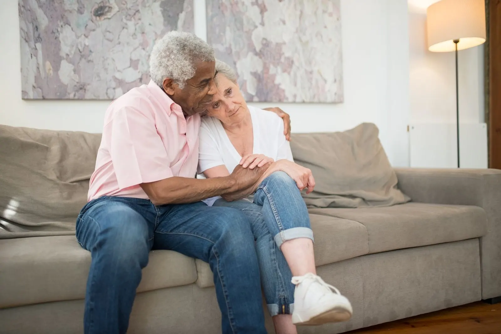 Pareja abrazada en el sofá, ternura entre mujer Aries y hombre Cáncer