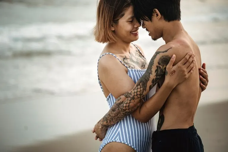 Hombre Cáncer y mujer Piscis: compatibilidad real Hombre Cáncer y mujer Piscis abrazados con ternura frente al mar al atardecer