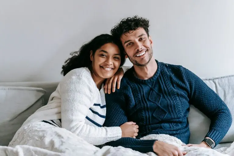 Hombre Cáncer y mujer Tauro: ternura y calma en pareja Hombre Cáncer y mujer Tauro abrazados en un sofá de un hogar acogedor