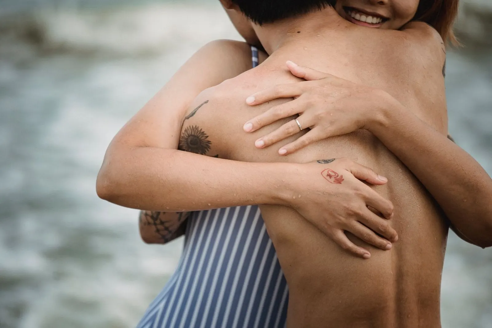 Hombre Escorpio y mujer Cáncer abrazados frente al mar al atardecer