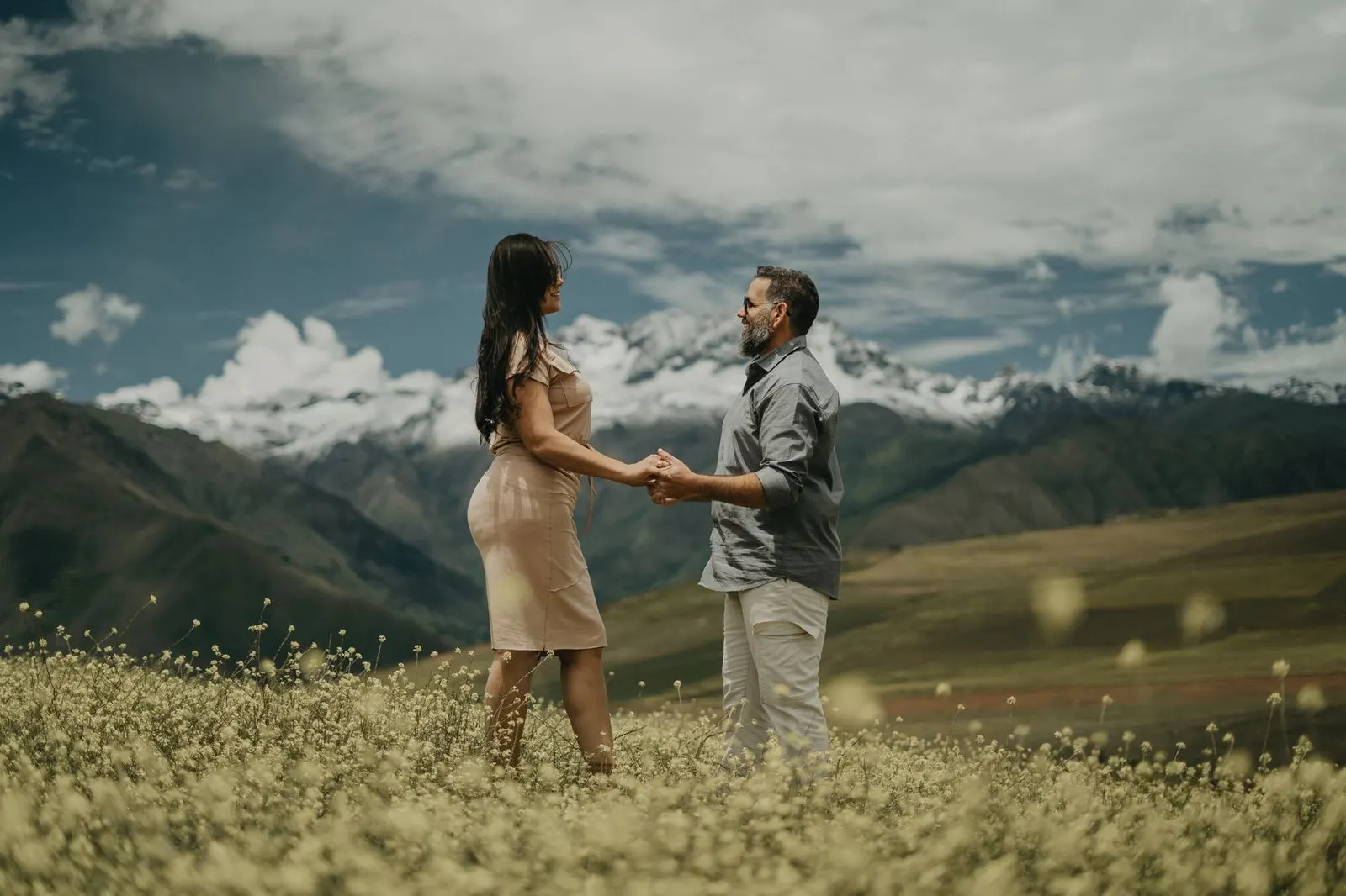 Mujer Capricornio y hombre Escorpio de la mano frente a un paisaje montañoso