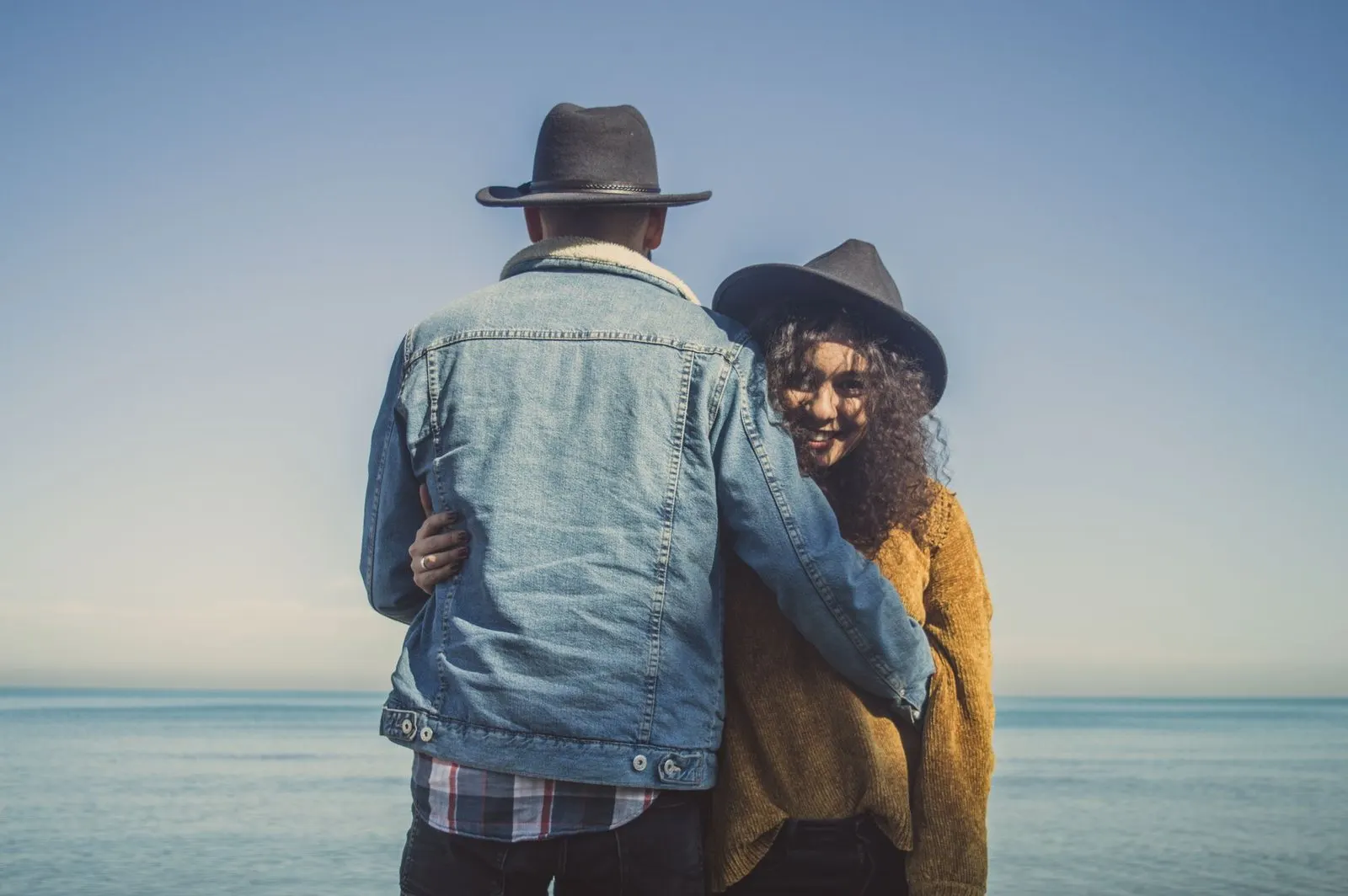 Pareja abrazada junto al mar, imagen del hombre Escorpio y mujer Piscis