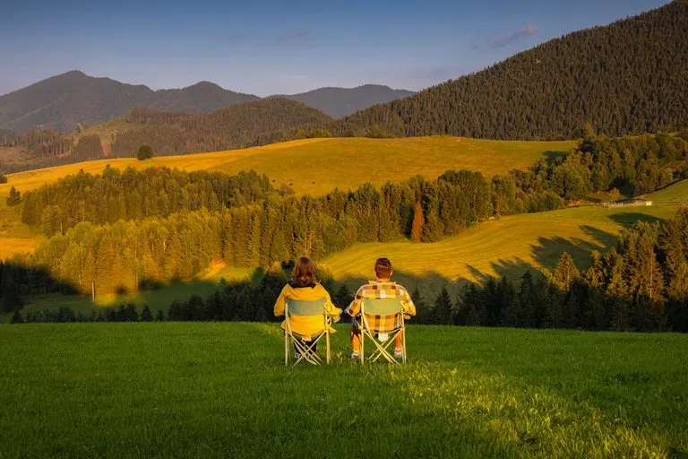 Hombre Escorpio y mujer Sagitario caminando juntos por la montaña al atardecer