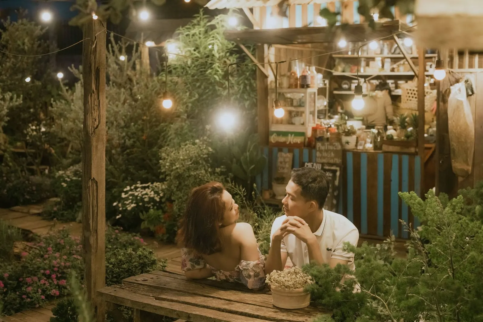 Hombre Géminis y mujer Escorpio conversando de forma intensa en un café al atardecer
