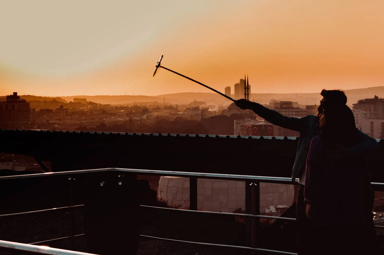 Pareja de hombre Leo y mujer Capricornio conversando en una terraza urbana al atardecer