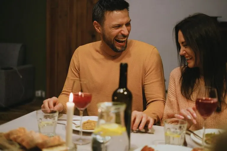 Hombre Leo y mujer Virgo: compatibilidad, amor y cama Hombre Leo y mujer Virgo compartiendo una cena íntima entre risas y complicidad