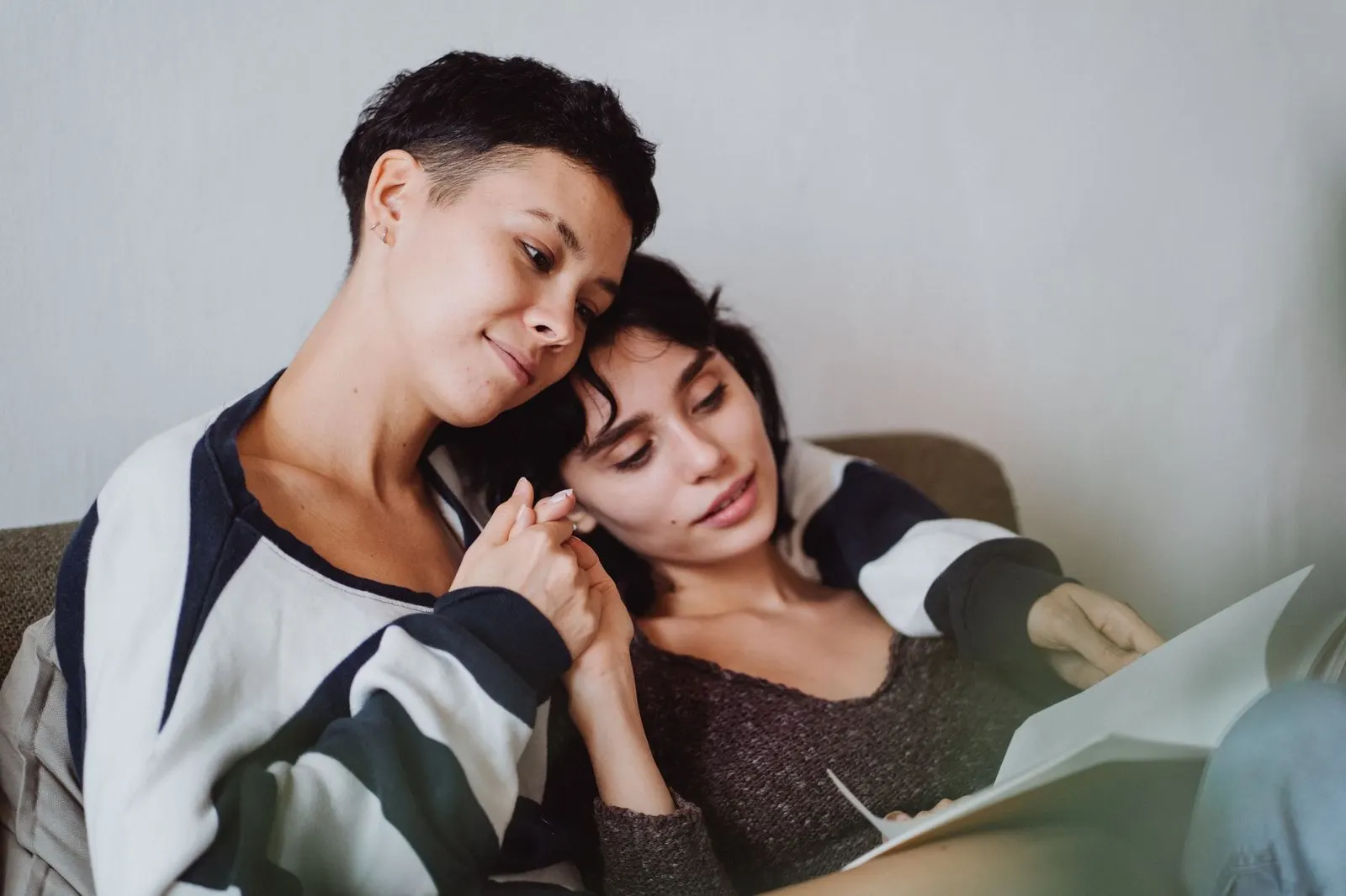 Hombre y mujer abrazados en el sofá, ternura entre Libra y Cáncer