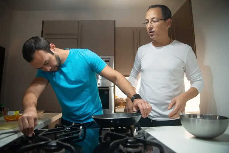 Hombre Libra y mujer Cáncer cocinando juntos en casa con complicidad