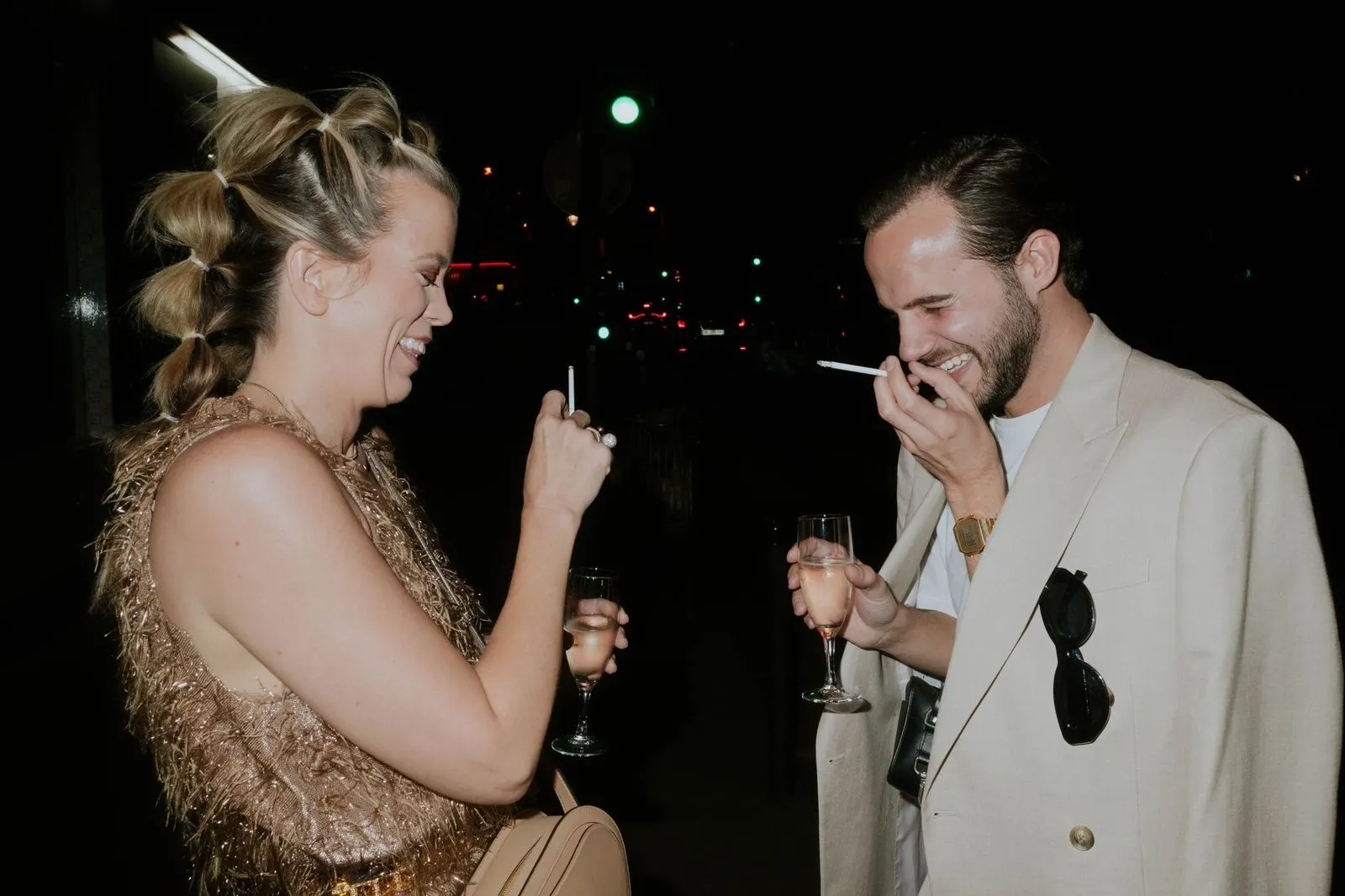 Pareja riendo en una fiesta, reflejo de la vida social entre Libra y Leo
