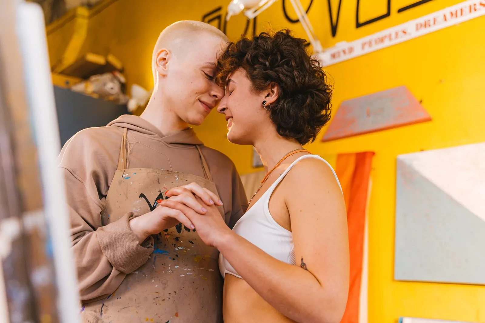 Mujer Piscis y hombre Libra pintando juntos en un estudio luminoso