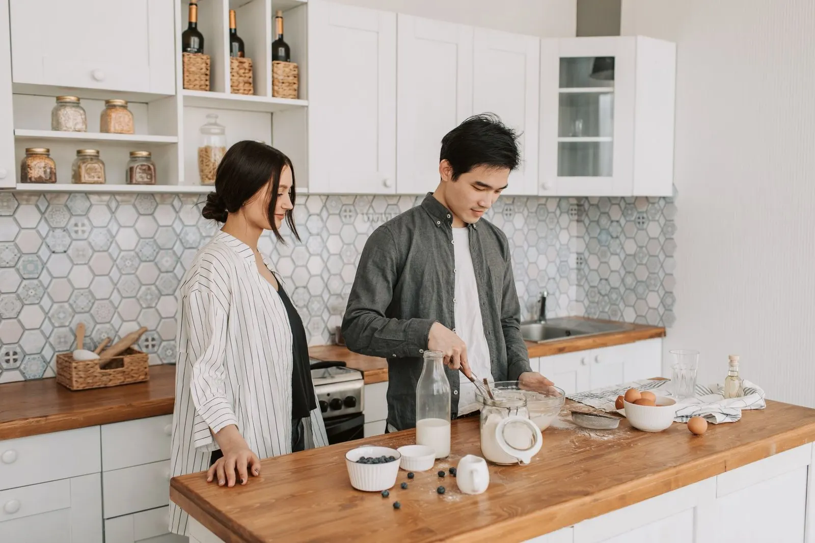 Hombre Virgo y mujer Cáncer cocinando juntos en una cocina acogedora y ordenada