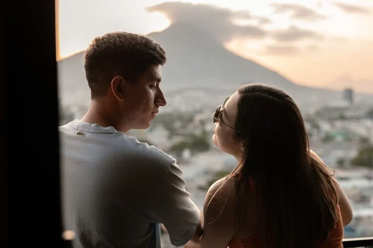 Hombre Virgo y mujer Leo: compatibilidad en el amor Hombre Virgo y mujer Leo riendo juntos en una terraza al atardecer